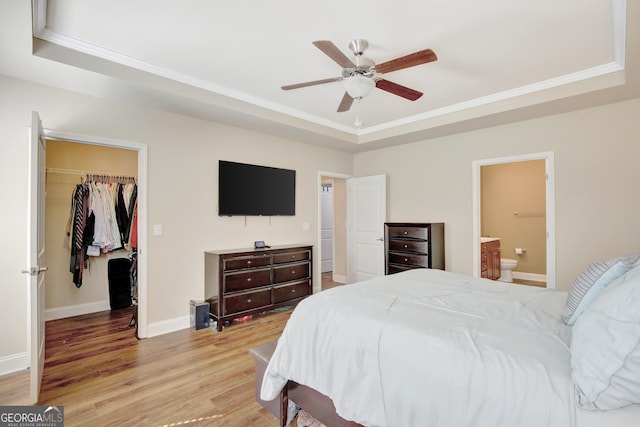 890 Crescent Ln, Griffin, GA 30224 - bedroom with a tray ceiling, a walk in closet, light wood finished floors, a closet, and crown molding