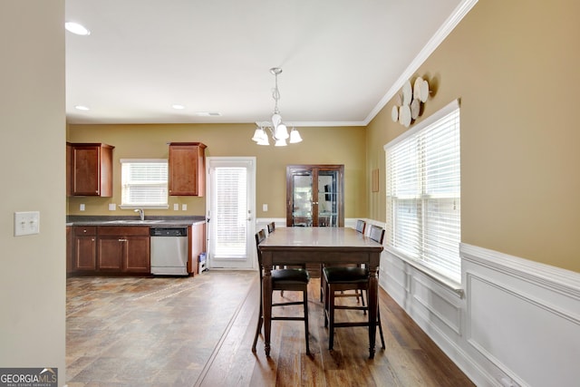 890 Crescent Ln, Griffin, GA 30224 - dining area with a chandelier, plenty of natural light, wainscoting, ornamental molding, and wood finished floors