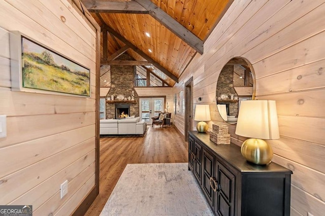 hall with wooden walls, hardwood / wood-style flooring, beam ceiling, and wood ceiling