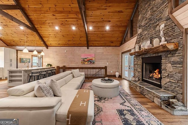 living room featuring light wood-style floors, wooden ceiling, beamed ceiling, and plenty of natural light