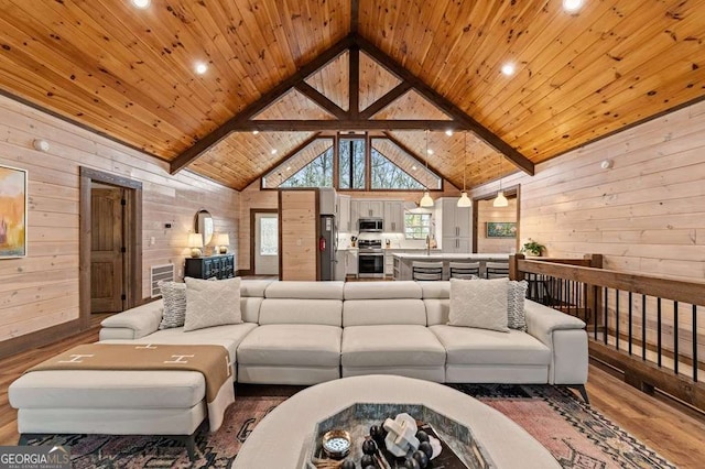 living area featuring wood walls, high vaulted ceiling, wooden ceiling, and wood finished floors