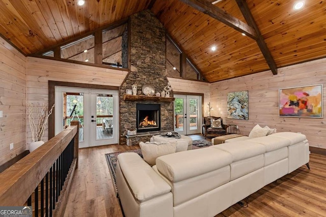 living area with wood ceiling, wooden walls, wood finished floors, french doors, and high vaulted ceiling