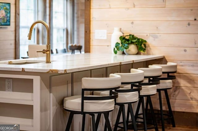 bar featuring wooden walls and a sink