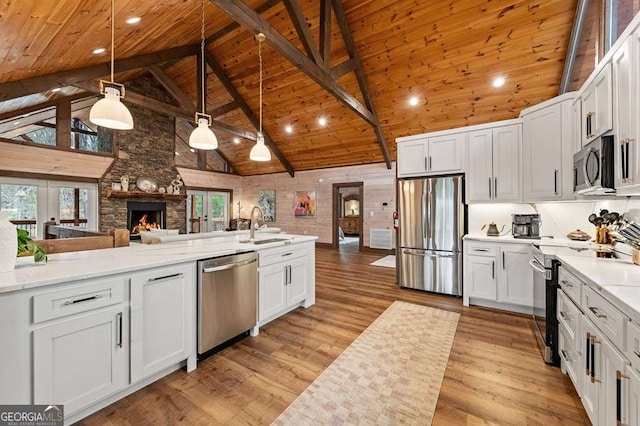 kitchen featuring open floor plan, light wood-type flooring, wood ceiling, stainless steel appliances, and high vaulted ceiling
