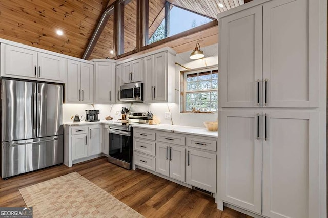 kitchen with dark wood-style flooring, light countertops, white cabinets, stainless steel appliances, and wooden ceiling