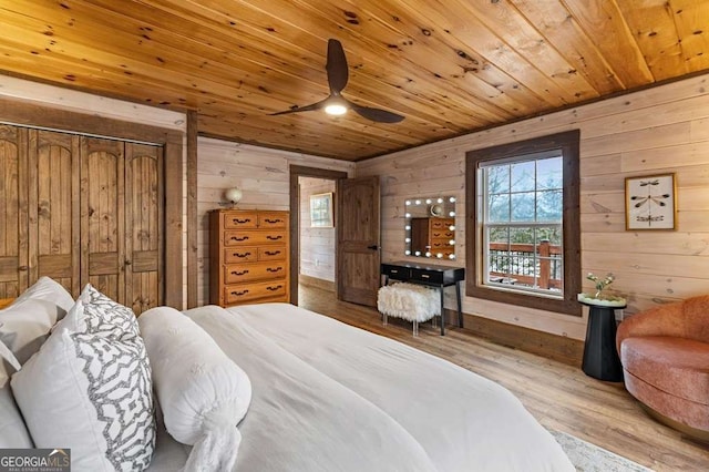 bedroom with wooden walls, multiple windows, and wooden ceiling