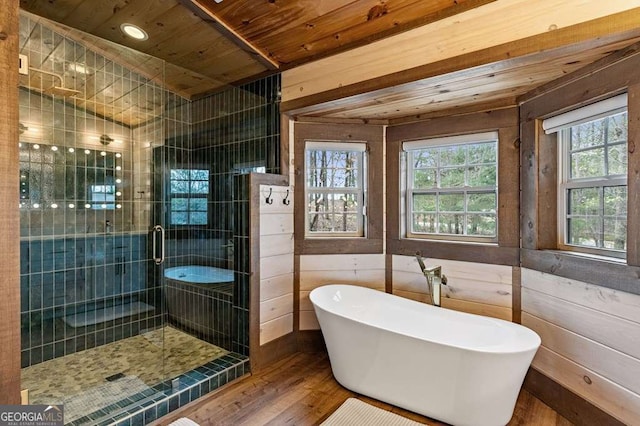 full bathroom featuring a freestanding bath, wood ceiling, a stall shower, and wood finished floors