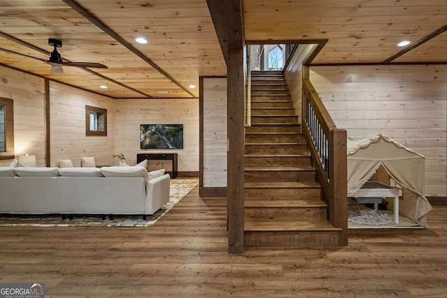 living area with wooden walls, stairway, wood finished floors, and wood ceiling
