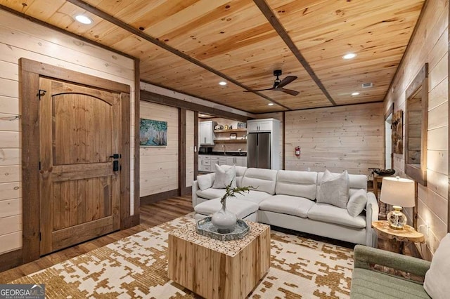 living room with wood walls, light wood-type flooring, and wood ceiling