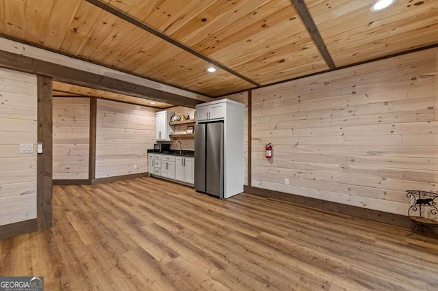 kitchen with freestanding refrigerator, open shelves, wooden ceiling, a sink, and dark countertops