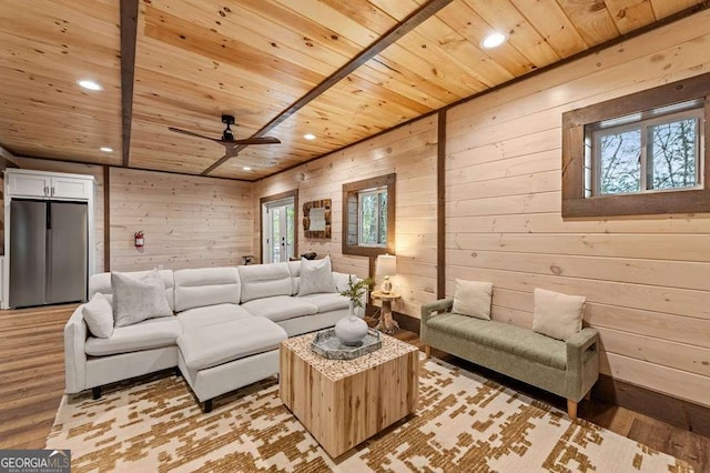 living room with wooden walls, light wood-style flooring, and wooden ceiling