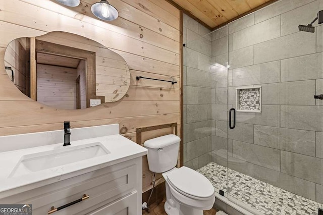 full bathroom featuring a shower stall, wooden walls, vanity, and toilet