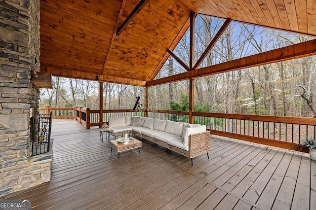 wooden terrace featuring a view of trees and an outdoor hangout area
