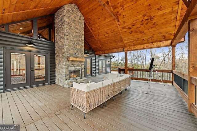 wooden deck with french doors and an outdoor living space with a fireplace