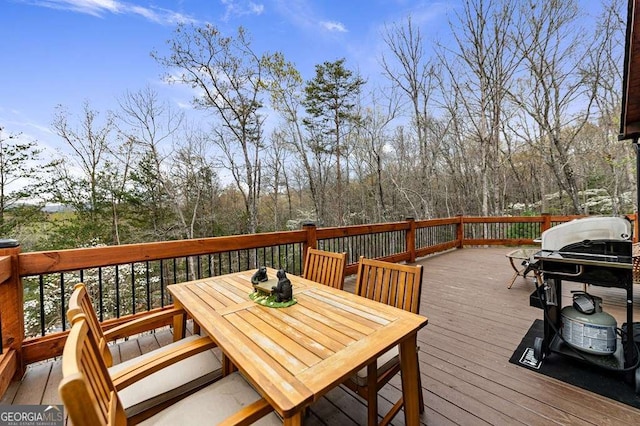 wooden terrace with outdoor dining space and area for grilling