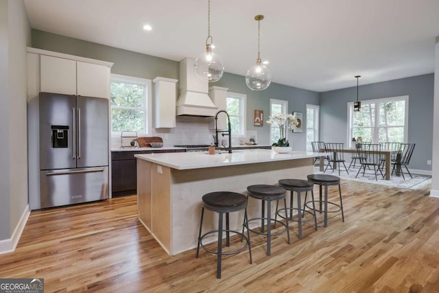 290 Hodgson Dr, Athens, GA 30606 - kitchen featuring white cabinetry, custom exhaust hood, light countertops, light wood finished floors, and high end fridge