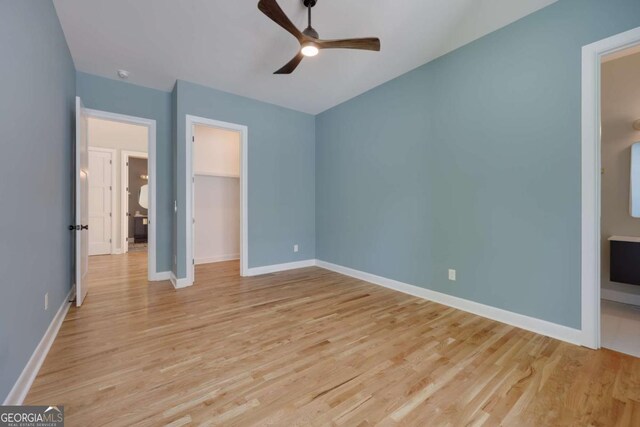 290 Hodgson Dr, Athens, GA 30606 - unfurnished bedroom featuring light wood-type flooring, baseboards, a closet, a spacious closet, and a ceiling fan