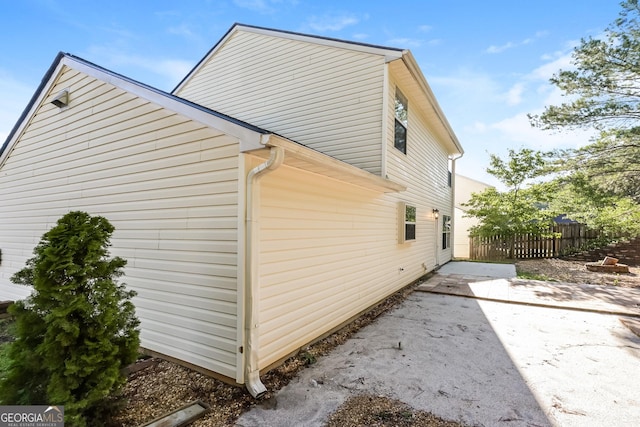view of home's exterior with a patio area and fence