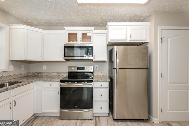 kitchen featuring a sink, white cabinetry, and stainless steel appliances