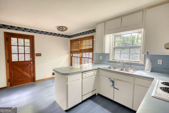 kitchen with white cabinets, a peninsula, a sink, white appliances, and light countertops