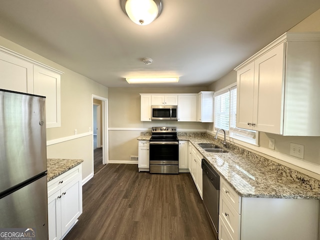 2361 Whites Mill Rd, Decatur, GA 30032 - kitchen featuring white cabinets, a sink, appliances with stainless steel finishes, dark wood-type flooring, and light stone counters