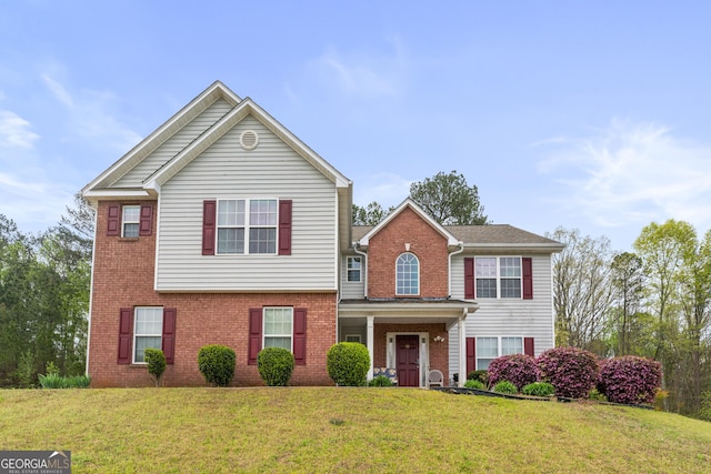 traditional home featuring brick siding and a front lawn