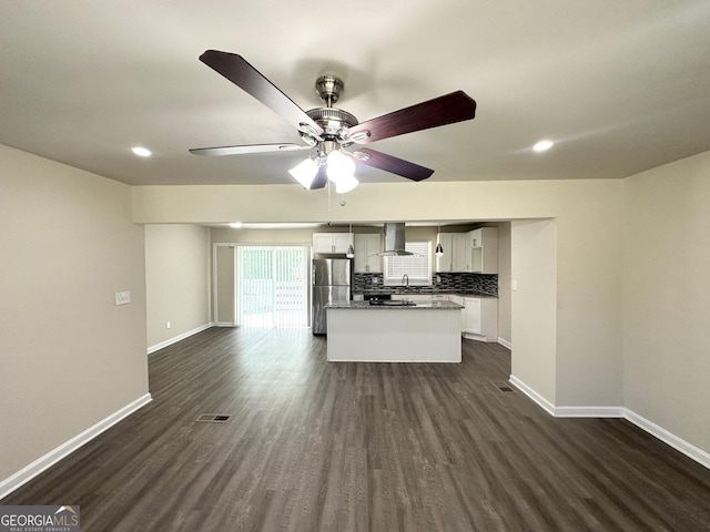 3191 Gay Dr, Decatur, GA 30032 - kitchen with wall chimney range hood, freestanding refrigerator, a ceiling fan, a kitchen island, and dark wood finished floors