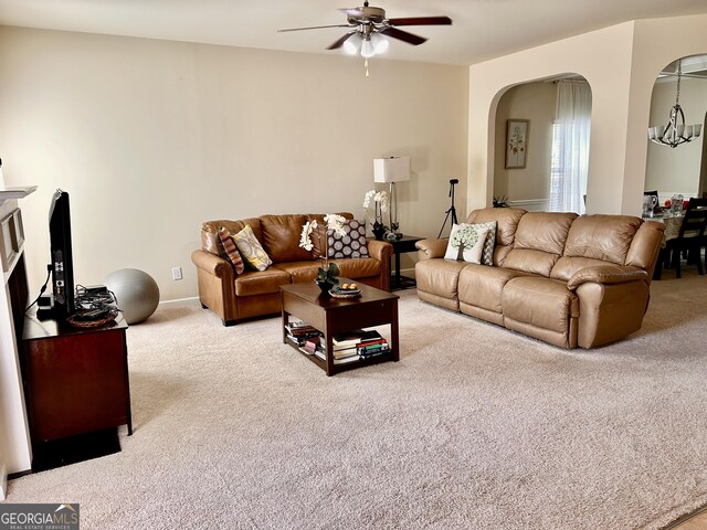 living room featuring a ceiling fan, arched walkways, and carpet