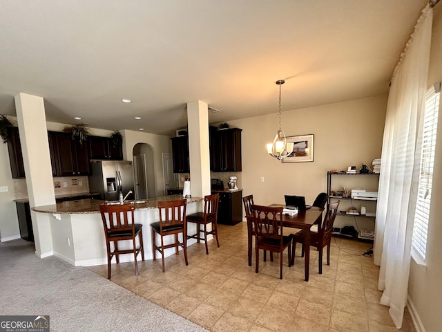 dining space featuring baseboards, recessed lighting, and arched walkways