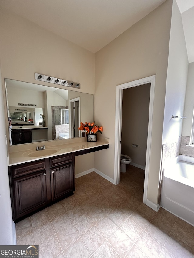 full bathroom with vanity, baseboards, walk in shower, toilet, and a garden tub