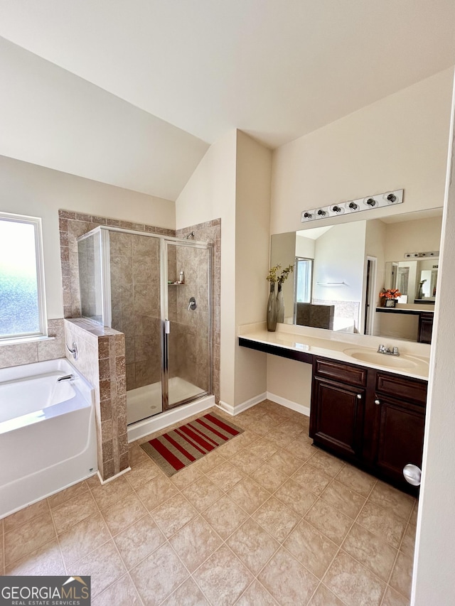full bath featuring a shower stall, a garden tub, vanity, tile patterned flooring, and lofted ceiling