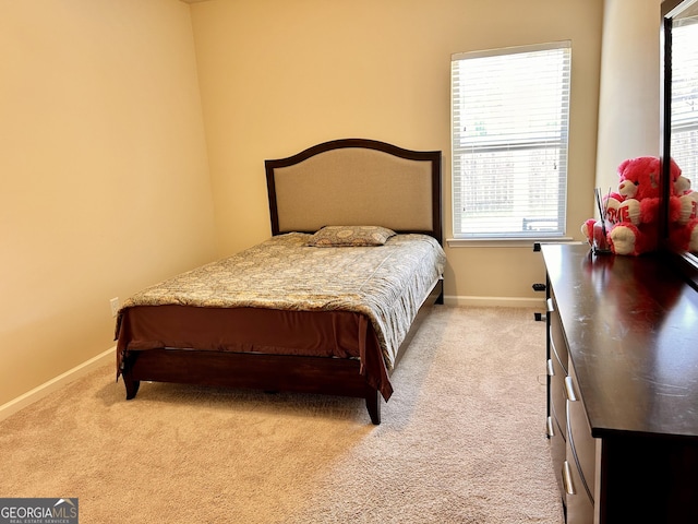 bedroom featuring light carpet and baseboards