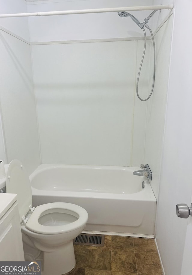 bathroom with toilet, bathtub / shower combination, vanity, and stone finish flooring