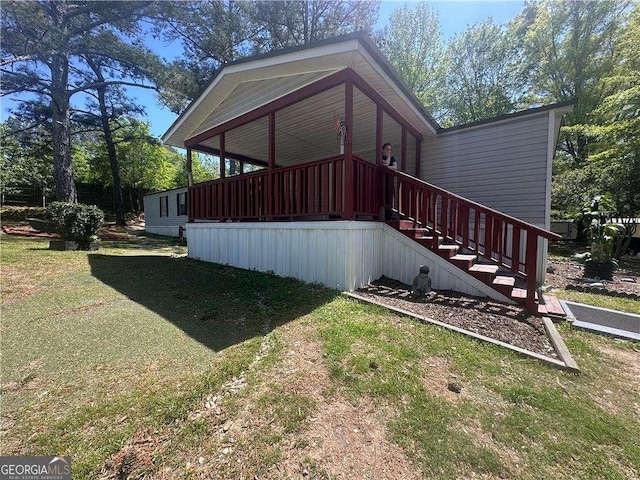 view of side of property with a lawn and stairway