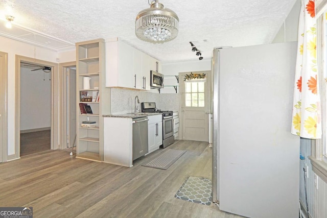 5024 Park Ave, Forest Park, GA 30297 - kitchen featuring a textured ceiling, white cabinetry, a sink, stainless steel appliances, and light wood finished floors