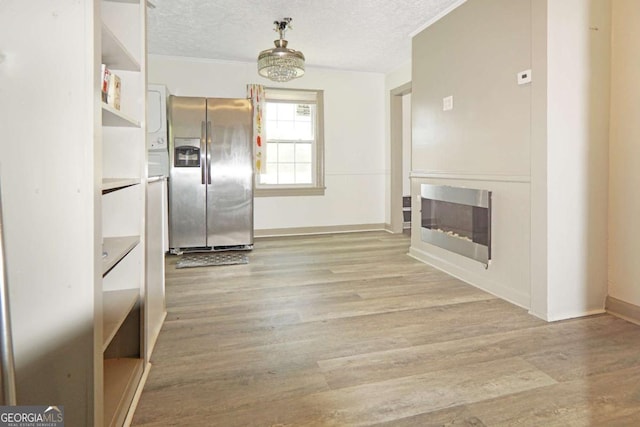 5024 Park Ave, Forest Park, GA 30297 - interior space with a glass covered fireplace, light wood-type flooring, a textured ceiling, and crown molding