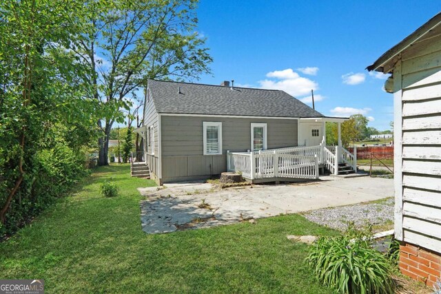 5024 Park Ave, Forest Park, GA 30297 - rear view of property with a yard, a shingled roof, and a deck