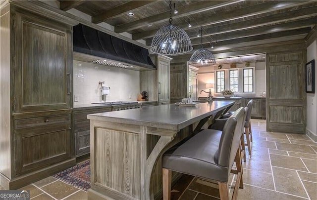 2979 Ridgewood Rd NW, Atlanta, GA 30327 - kitchen with wall chimney range hood, beam ceiling, stone tile flooring, wood ceiling, and a kitchen island