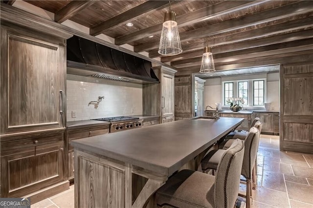 2979 Ridgewood Rd NW, Atlanta, GA 30327 - kitchen featuring wood ceiling, a kitchen island with sink, range hood, tasteful backsplash, and a sink