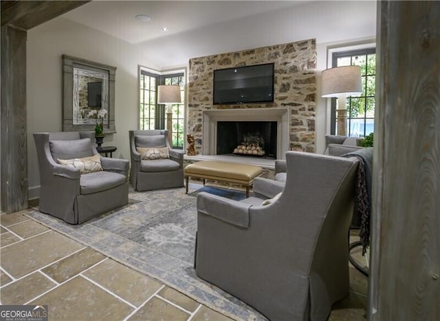 2979 Ridgewood Rd NW, Atlanta, GA 30327 - living room featuring stone tile flooring, a fireplace, and healthy amount of natural light