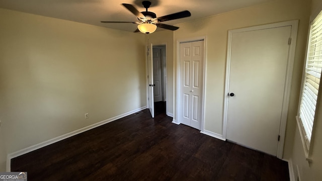 1093 Grace St SW, Mableton, GA 30126 - unfurnished bedroom with ceiling fan, multiple windows, dark wood-style floors, and baseboards