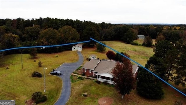 drone / aerial view with a wooded view