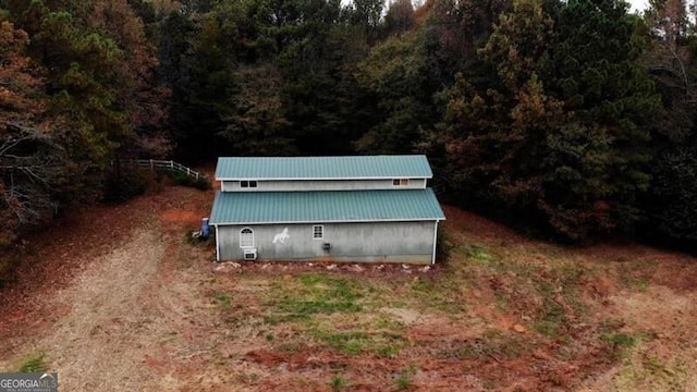 exterior space with a forest view and an outbuilding