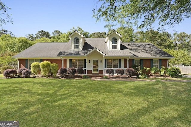 387 Sandhurst Dr, Richmond Hill, GA 31324 - cape cod house with roof with shingles, a front yard, and brick siding