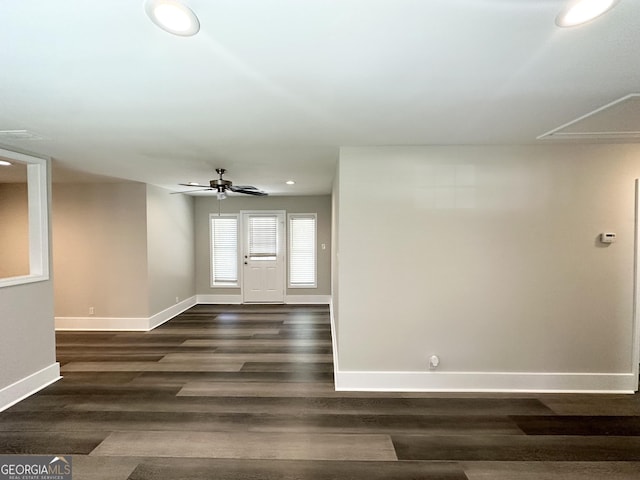 unfurnished room with dark wood-style flooring, attic access, baseboards, and recessed lighting