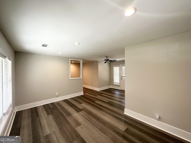 empty room featuring baseboards, dark wood finished floors, visible vents, and recessed lighting