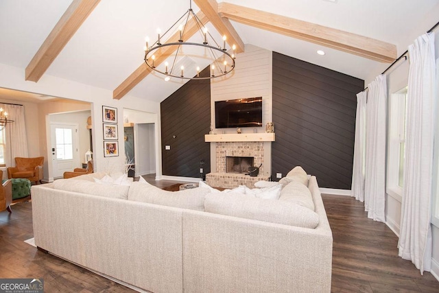 living room featuring a fireplace, lofted ceiling with beams, a chandelier, dark wood-style flooring, and wooden walls