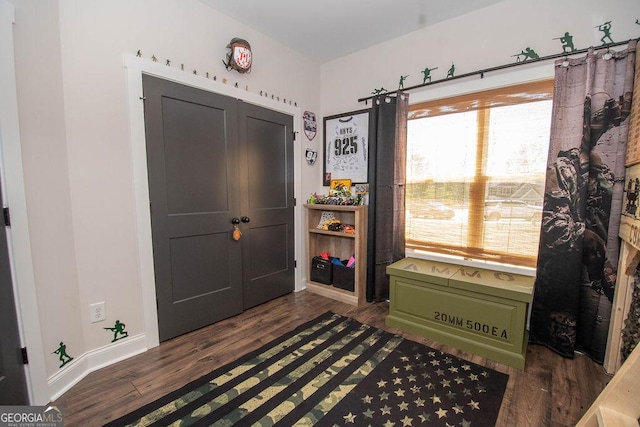 foyer featuring plenty of natural light, baseboards, and dark wood finished floors