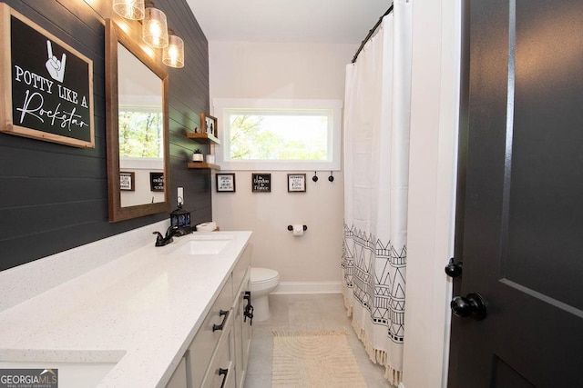 bathroom featuring toilet, tile patterned floors, vanity, and baseboards
