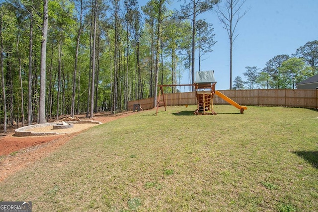 view of yard featuring fence and a playground